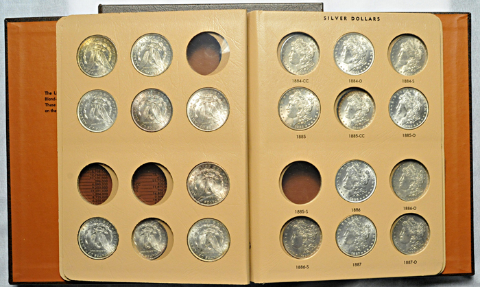 Three partially filled albums of Morgan dollars.